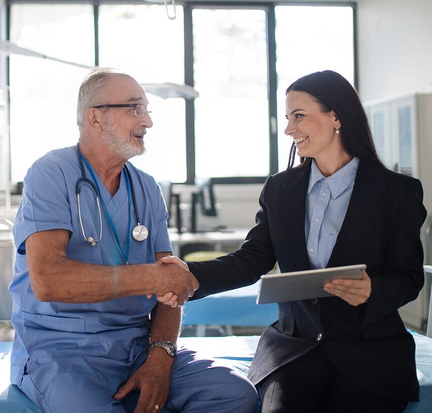 young-business-woman-shaking-hand-with-elderly-doc-2024-10-19-22-44-17-utc 1